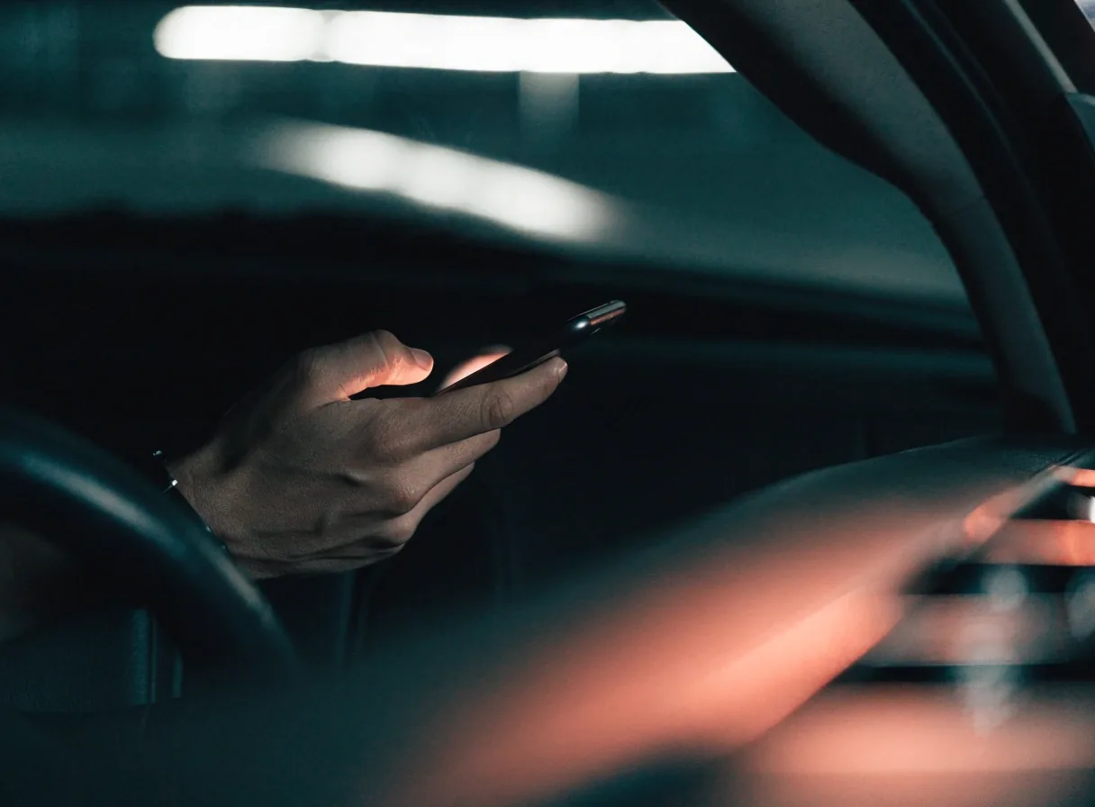 Phone held ready for QR entry inside a dark car